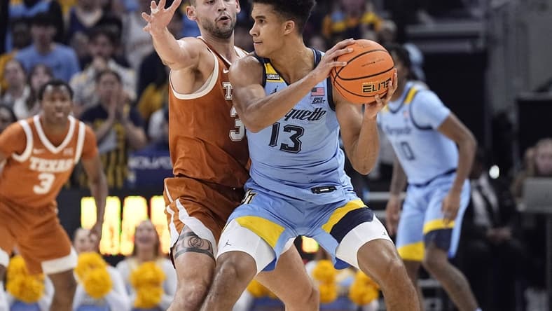 Dec 6, 2023; Milwaukee, Wisconsin, USA; Marquette Golden Eagles forward Oso Ighodaro (13) looks to pass the ball under pressure from Texas Longhorns forward Brock Cunningham (30) during the first half at Fiserv Forum. Mandatory Credit: Jeff Hanisch-USA TODAY Sports