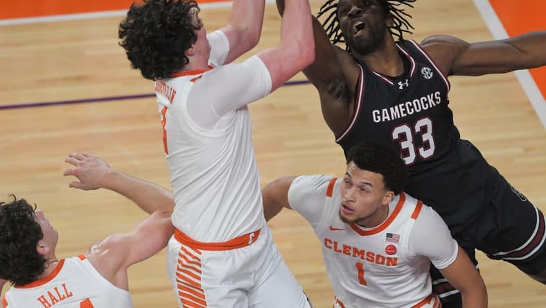 Dec 6, 2023; Clemson, South Carolina, USA; Clemson junior forward Ian Schieffelin (4) rebounds ear University of South Carolina forward Josh Gray (33) during the first half at Littlejohn Coliseum. Mandatory Credit: Ken Ruinard-USA TODAY Sports