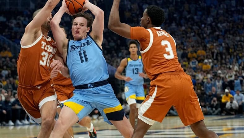Marquette guard Tyler Kolek (11) is double-teamed b y Texas forward Brock Cunningham (30) and guard Max Abmas (3) during the first half of their game Wednesday, December 6, 2023 at Fiserv Forum in Milwaukee, Wisconsin.