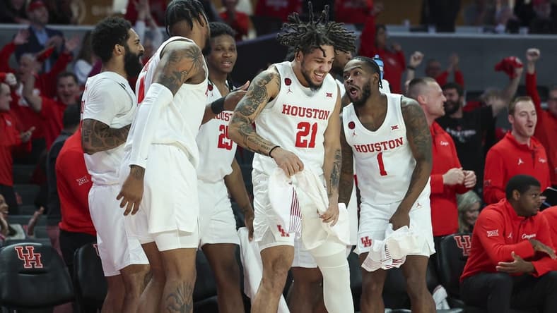 Dec 6, 2023; Houston, Texas, USA; Houston Cougars guard Emanuel Sharp (21) celebrates with teammates after a play during the second half against the Rice Owls at Fertitta Center. Mandatory Credit: Troy Taormina-USA TODAY Sports