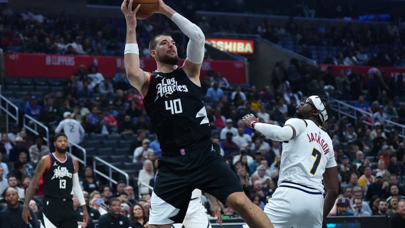 Dec 6, 2023; Los Angeles, California, USA; LA Clippers center Ivica Zubac (40) shoots the ball against Denver Nuggets guard Reggie Jackson (7) in the first half at Crypto.com Arena. Mandatory Credit: Kirby Lee-USA TODAY Sports