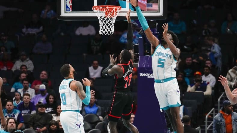 Dec 8, 2023; Charlotte, North Carolina, USA; Charlotte Hornets center Mark Williams (5) blocks a shot by Toronto Raptors guard Dennis Schroder (17)  during the first quarter at the Spectrum Center. Mandatory Credit: Jim Dedmon-USA TODAY Sports