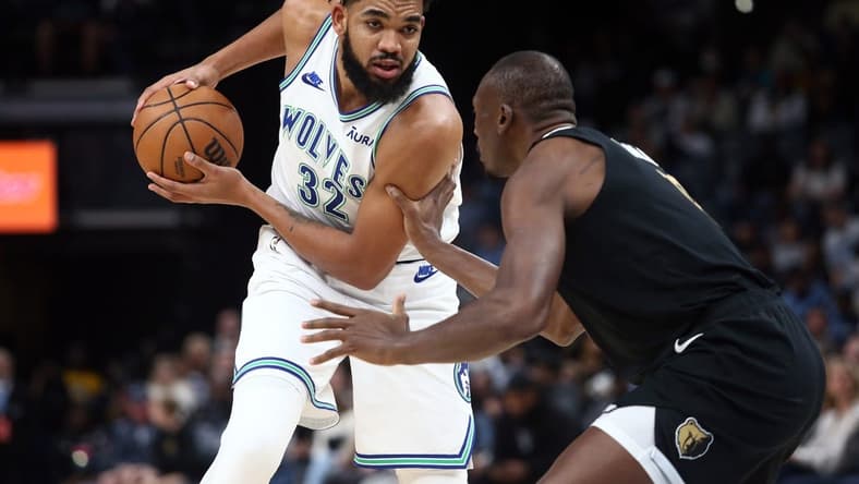 Dec 8, 2023; Memphis, Tennessee, USA; Minnesota Timberwolves center-forward Karl-Anthony Towns (32) handles the ball as Memphis Grizzlies center Bismack Biyombo (18) defends during the first half at FedExForum. Mandatory Credit: Petre Thomas-USA TODAY Sports