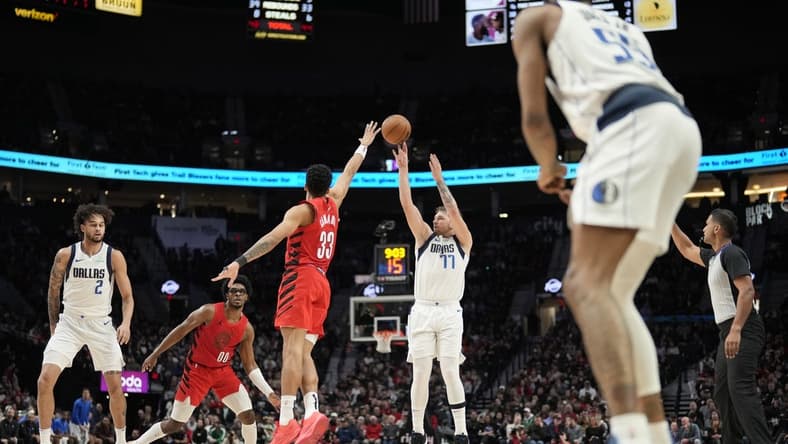 Dec 8, 2023; Portland, Oregon, USA; Dallas Mavericks point guard Luka Doncic (77) shoots the ball over Portland Trail Blazers forward Toumani Camara (33) during the second half at Moda Center. Mandatory Credit: Soobum Im-USA TODAY Sports