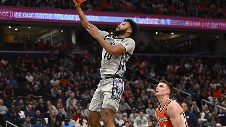 Dec 9, 2023; Washington, District of Columbia, USA; Georgetown Hoyas guard Jayden Epps (10) shoots as Syracuse Orange center Naheem McLeod (10) looks on during the second half at Capital One Arena. Mandatory Credit: Brad Mills-USA TODAY Sports