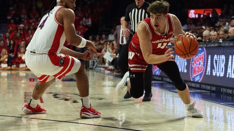 Dec 9, 2023; Tucson, Arizona, USA; Wisconsin Badgers guard Max Klesmit (11) drives to the net against Arizona Wildcats guard Kylan Boswell (4) during the first half at McKale Center. Mandatory Credit: Zachary BonDurant-USA TODAY Sports