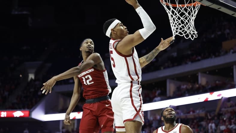 Dec 9, 2023; Tulsa, Oklahoma, USA; Oklahoma Sooners guard Rivaldo Soares (5) shoots beside Arkansas Razorbacks guard Tramon Mark (12) during the first half at BOK Center. Mandatory Credit: Alonzo Adams-USA TODAY Sports