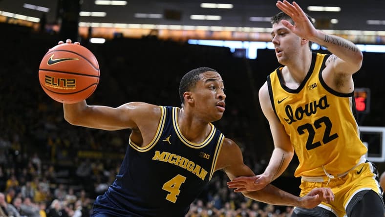 Dec 10, 2023; Iowa City, Iowa, USA; Michigan Wolverines guard Nimari Burnett (4) controls the ball as Iowa Hawkeyes forward Patrick McCaffery (22) defends during the first half at Carver-Hawkeye Arena. Mandatory Credit: Jeffrey Becker-USA TODAY Sports
