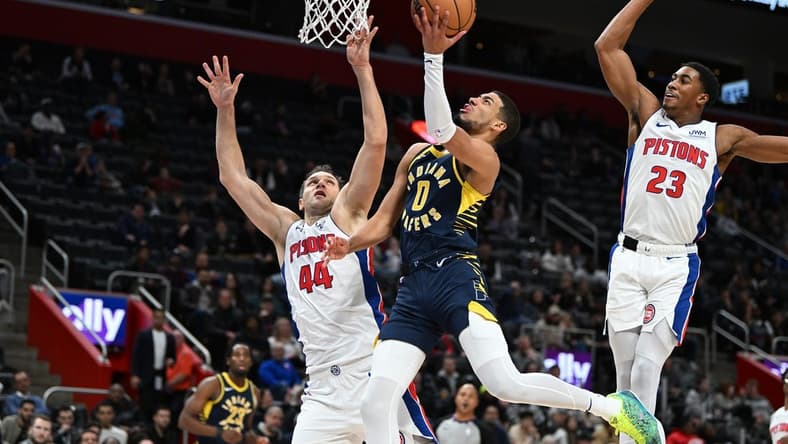 Dec 11, 2023; Detroit, Michigan, USA;  Indiana Pacers guard Tyrese Haliburton (0) drives to the basket against Detroit Pistons forward Bojan Bogdanovic (44) and Pistons guard Jaden Ivey (23) in the second quarter at Little Caesars Arena. Mandatory Credit: Lon Horwedel-USA TODAY Sports
