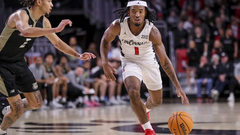 Dec 12, 2023; Cincinnati, Ohio, USA; Cincinnati Bearcats guard Day Day Thomas (1) dribbles against Bryant Bulldogs guard Tyler Brelsford (2) in the second half at Fifth Third Arena. Mandatory Credit: Katie Stratman-USA TODAY Sports