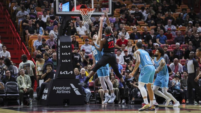Dec 13, 2023; Miami, Florida, USA; Miami Heat forward Jimmy Butler (22) shoots the basketball over Charlotte Hornets forward Gordon Hayward (20) during the first quarter at Kaseya Center. Mandatory Credit: Sam Navarro-USA TODAY Sports