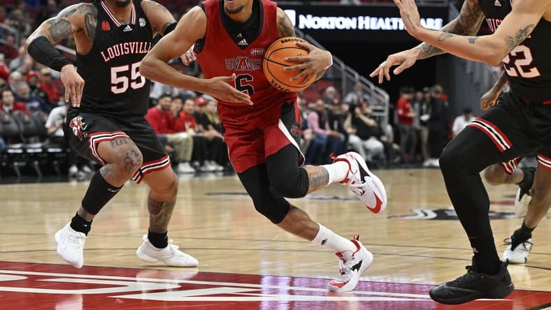 Dec 13, 2023; Louisville, Kentucky, USA; Arkansas State Red Wolves guard Taryn Todd (6) drives to the basket against Louisville Cardinals guard Skyy Clark (55) and guard Tre White (22) during the first half at KFC Yum! Center. Mandatory Credit: Jamie Rhodes-USA TODAY Sports