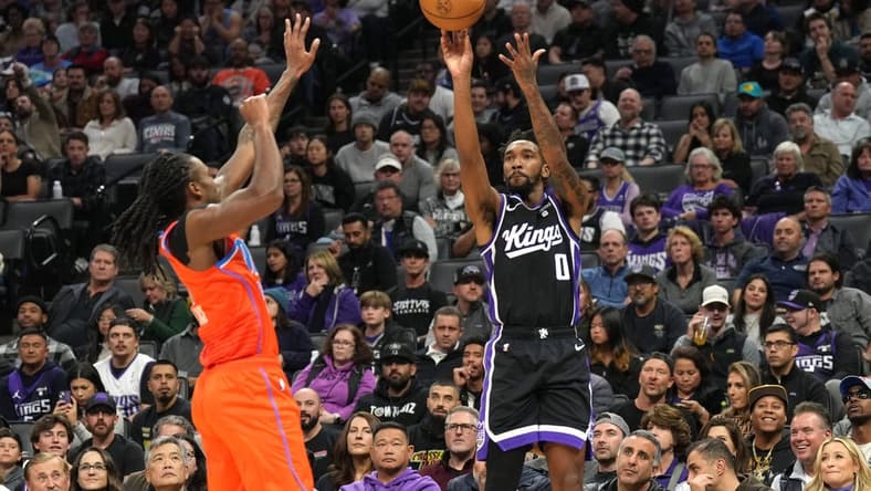 Dec 14, 2023; Sacramento, California, USA; Sacramento Kings guard Malik Monk (0) shoots against Oklahoma City Thunder guard Cason Wallace (left) during the second quarter at Golden 1 Center. Mandatory Credit: Darren Yamashita-USA TODAY Sports
