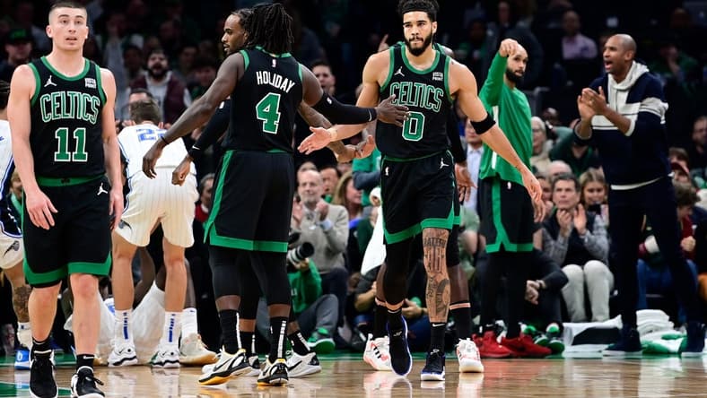 Dec 15, 2023; Boston, Massachusetts, USA; Boston Celtics forward Jayson Tatum (0) reacts to his shot with guard Jrue Holiday (4) during the first half against the Orlando Magic at TD Garden. Mandatory Credit: Eric Canha-USA TODAY Sports