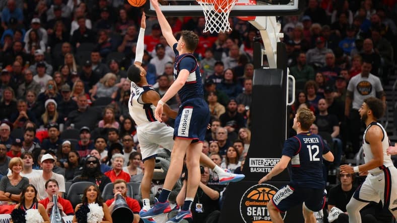 Dec 15, 2023; Seattle, Washington, USA; Connecticut Huskies center Donovan Clingan (32) blocks the shot attempt by Gonzaga Bulldogs guard Nolan Hickman (11) during the second half at Climate Pledge Arena. Mandatory Credit: Steven Bisig-USA TODAY Sports