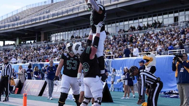 Dec 16, 2023; Conway, SC, USA; Ohio Bobcats running back Rickey Hunt (28) is lifted into the air by Ohio Bobcats offensive lineman Parker Titsworth (69) after a touchdown in the first half against the Georgia Southern Eagles at Brooks Stadium. Mandatory Credit: David Yeazell-USA TODAY Sports
