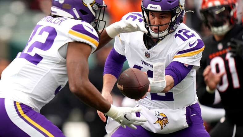 Dec 16, 2023; Cincinnati, Ohio, USA; Minnesota Vikings quarterback Nick Mullens (12) hands the ball off to Minnesota Vikings running back Ty Chandler (32) in the first quarter of the game against the Cincinnati Bengals at Paycor Stadium. Mandatory Credit: Kareem Elgazzar/The Enquirer-USA TODAY Sports