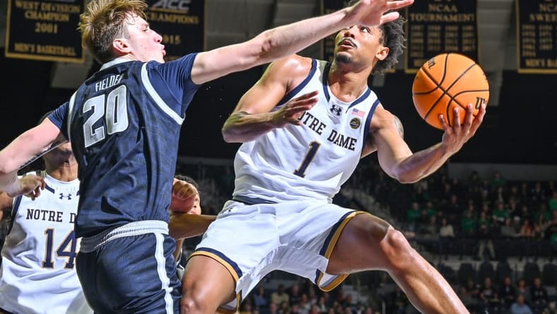 Dec 16, 2023; South Bend, Indiana, USA; Notre Dame Fighting Irish guard Julian Roper II (1) goes up for a shot as Georgetown Hoyas forward Drew Fielder (20) defends in the first half at the Purcell Pavilion. Mandatory Credit: Matt Cashore-USA TODAY Sports
