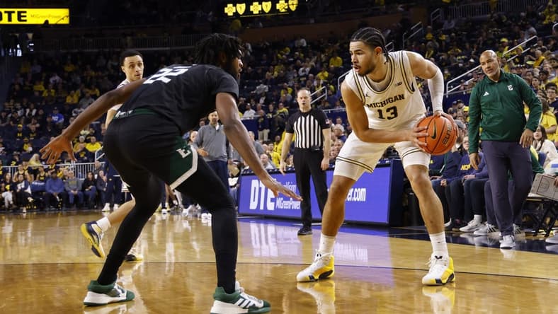 Dec 16, 2023; Ann Arbor, Michigan, USA; Michigan Wolverines forward Olivier Nkamhoua (13) is defended by Eastern Michigan Eagles forward Yusuf Jihad (22) in the first half at Crisler Center. Mandatory Credit: Rick Osentoski-USA TODAY Sports