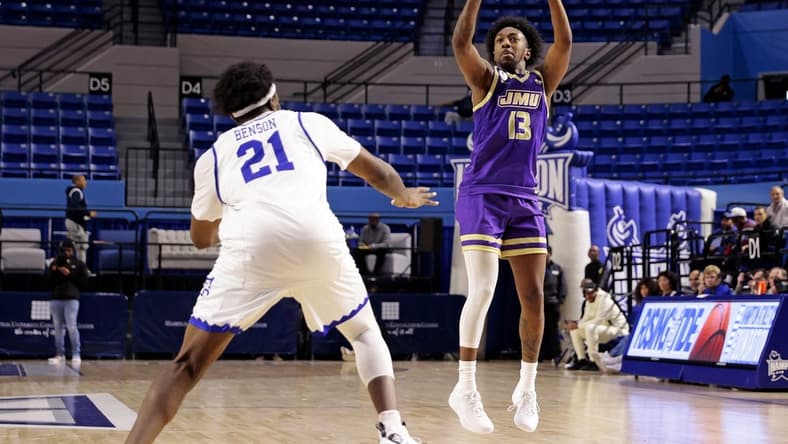 Dec 16, 2023; Hampton, Virginia, USA; James Madison Dukes guard Michael Green III (13) shoots the ball against Hampton Pirates forward Ja'Von Benson (21) during the second half at Hampton Convocation Center. Mandatory Credit: Peter Casey-USA TODAY Sports