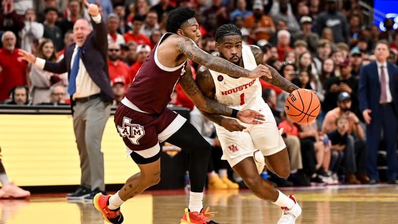 Dec 16, 2023; Houston, Texas, USA; Houston Cougars guard Jamal Shead (1) drives to the basket as Texas A&M Aggies guard Wade Taylor IV (4) defends during the second half at Toyota Center. Mandatory Credit: Maria Lysaker-USA TODAY Sports