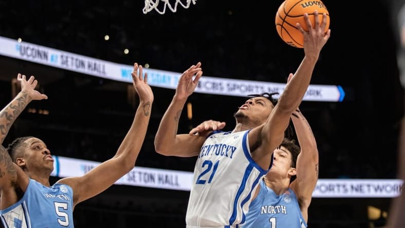 Dec 16, 2023; Atlanta, Georgia, USA; Kentucky Wildcats guard D.J. Wagner (21) attempts layup shot against North Carolina Tar Heels forward Armando Bacot (5) and North Carolina Tar Heels forward Zayden High (1) during the first half at State Farm Arena. Mandatory Credit: Jordan Godfree-USA TODAY Sports
