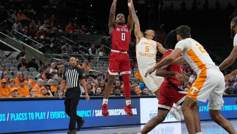 Dec 16, 2023; San Antonio, Texas, USA; North Carolina State Wolfpack guard DJ Horne (0) shoots over Tennessee Volunteers guard Zakai Zeigler (5) in the first half at the Frost Bank Center. Mandatory Credit: Daniel Dunn-USA TODAY Sports