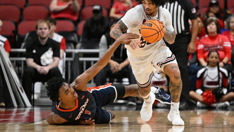 Dec 17, 2023; Louisville, Kentucky, USA; Louisville Cardinals guard Skyy Clark (55) dribbles against Pepperdine Waves guard Michael Ajayi (1) during the second half at KFC Yum! Center. Louisville defeated Pepperdine 85-63. Mandatory Credit: Jamie Rhodes-USA TODAY Sports