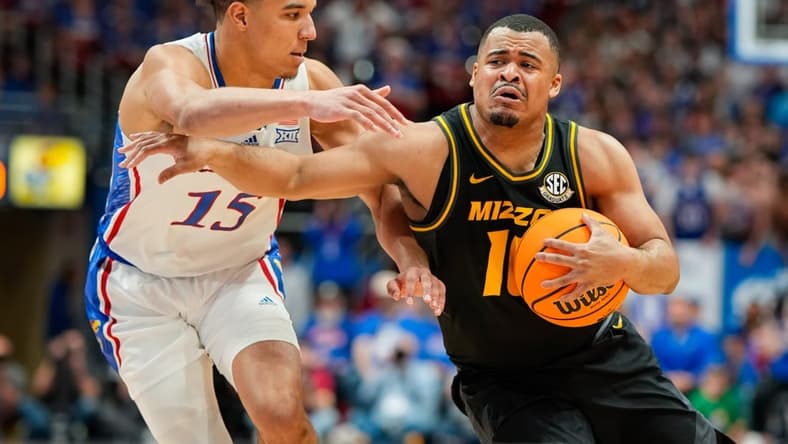 Dec 9, 2023; Lawrence, Kansas, USA; Missouri Tigers guard Nick Honor (10) drives against Kansas Jayhawks guard Kevin McCullar Jr. (15) during the first half at Allen Fieldhouse. Mandatory Credit: Jay Biggerstaff-USA TODAY Sports
