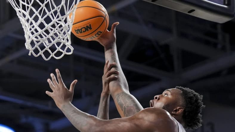Dec 19, 2023; Cincinnati, Ohio, USA; Cincinnati Bearcats forward Jamille Reynolds (13) attempts a dunk as he is fouled by Merrimack Warriors guard Devon Savage (5) in the first half at Fifth Third Arena. Mandatory Credit: Aaron Doster-USA TODAY Sports