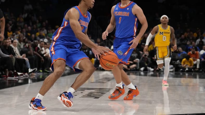 Dec 19, 2023; Charlotte, North Carolina, USA; Florida Gators guard Zyon Pullin (0) handles the ball watched by guard Walter Clayton Jr. (1) during the second half against the Michigan Wolverines at Spectrum Center. Mandatory Credit: Jim Dedmon-USA TODAY Sports