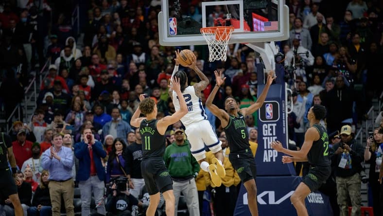 Dec 19, 2023; New Orleans, Louisiana, USA; Memphis Grizzlies guard Ja Morant (12) attempts the game winning basket against New Orleans Pelicans guard Dyson Daniels (11) and forward Herbert Jones (5) during the fourth quarter against the New Orleans Pelicans at the Smoothie King Center. Mandatory Credit: Matthew Hinton-USA TODAY Sports