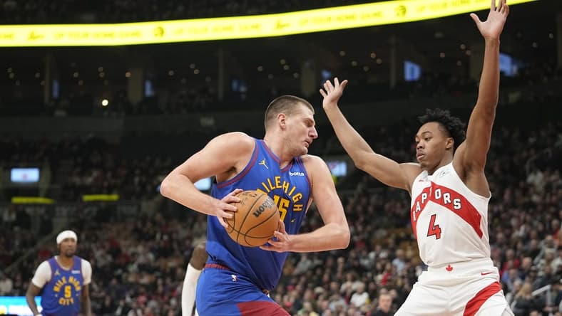 Dec 20, 2023; Toronto, Ontario, CAN; Denver Nuggets center Nikola Jokic (15) drives to the net against Toronto Raptors forward Scottie Barnes (4) during the first half at Scotiabank Arena. Mandatory Credit: John E. Sokolowski-USA TODAY Sports