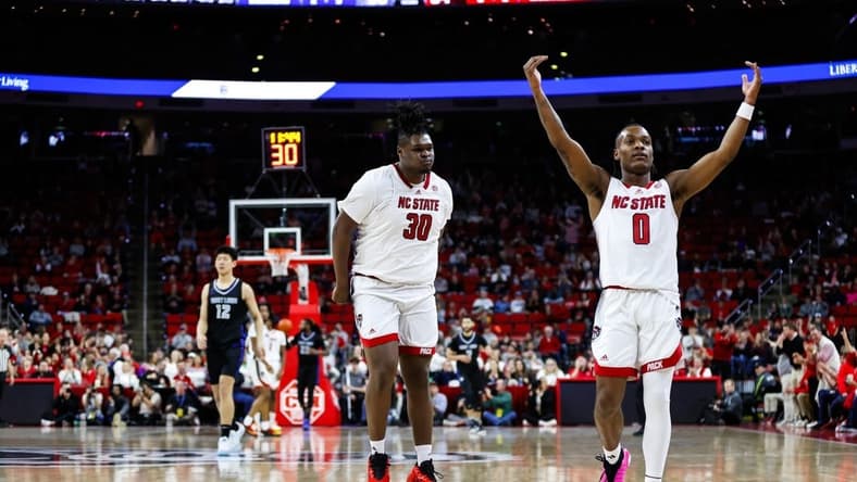 Dec 20, 2023; Raleigh, North Carolina, USA; North Carolina State Wolfpack guard DJ Horne (0) scores a three pointer and reacts with forward DJ Burns Jr. (30) during the second half against Saint Louis Billikens at PNC Arena. Mandatory Credit: Jaylynn Nash-USA TODAY Sports