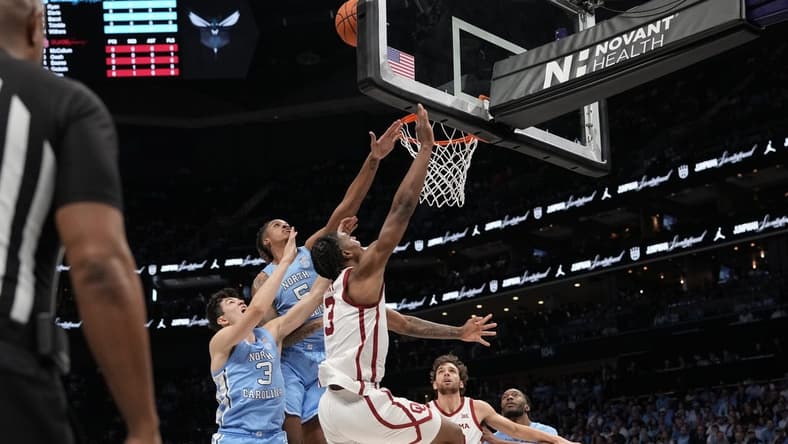 Dec 20, 2023; Charlotte, North Carolina, USA; Oklahoma Sooners guard Otega Oweh (3) has his shot blocked by North Carolina Tar Heels forward Armando Bacot (5) during the first half at Spectrum Center. Mandatory Credit: Jim Dedmon-USA TODAY Sports
