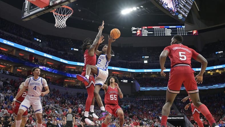 Dec 21, 2023; Louisville, Kentucky, USA;  Kentucky Wildcats guard Antonio Reeves (12) shoots against Louisville Cardinals guard Mike James (0) during the first half at KFC Yum! Center. Mandatory Credit: Jamie Rhodes-USA TODAY Sports
