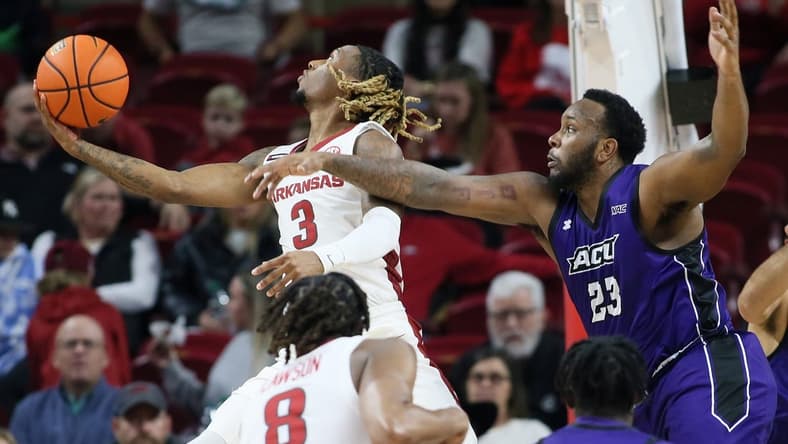 Dec 21, 2023; Fayetteville, Arkansas, USA; Arkansas Razorbacks guard El Ellis (3) shoots as Abilene Christian Wildcats forward Airion Simmons (23) defends during the first half at Bud Walton Arena. Mandatory Credit: Nelson Chenault-USA TODAY Sports