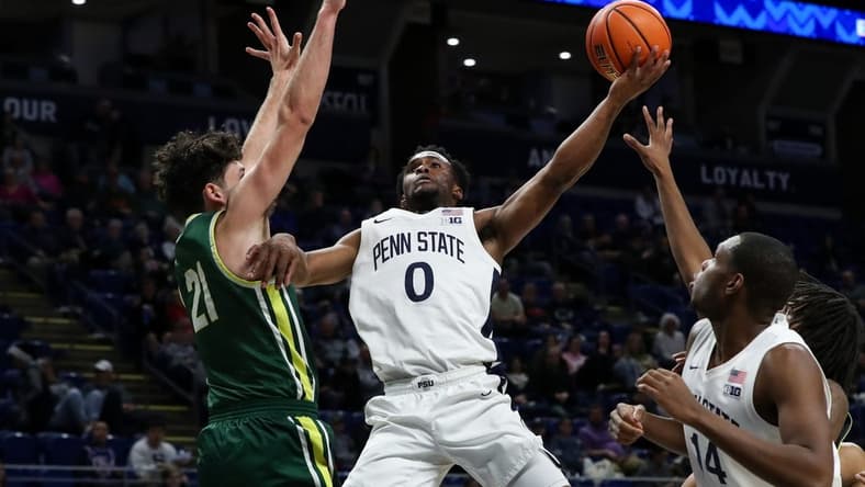 Dec 21, 2023; University Park, Pennsylvania, USA; Penn State Nittany Lions guard Kanye Clary (0) drives the ball to the basket as Le Moyne Dolphins guard Trent Mosquera (21) defends during the first half at Bryce Jordan Center. Mandatory Credit: Matthew O'Haren-USA TODAY Sports