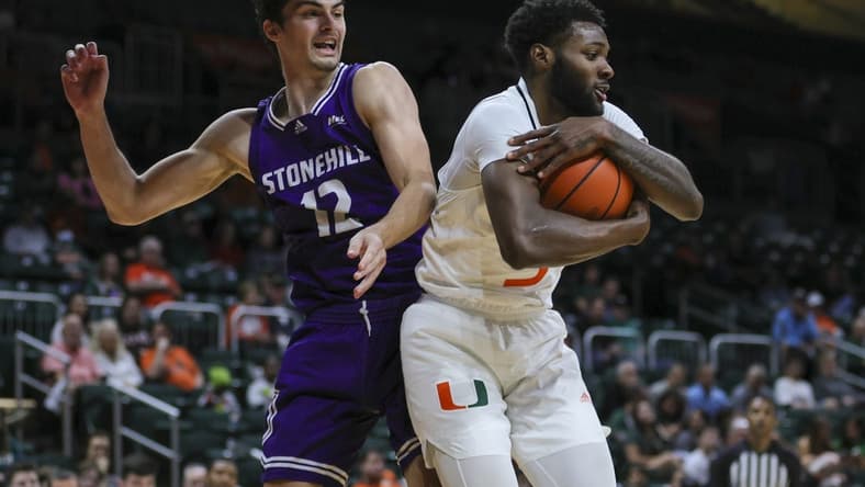 Dec 21, 2023; Coral Gables, Florida, USA; Miami Hurricanes guard Wooga Poplar (5) grabs a rebound against Stonehill Skyhawks guard Thatcher Stone (12) during the first half at Watsco Center. Mandatory Credit: Sam Navarro-USA TODAY Sports