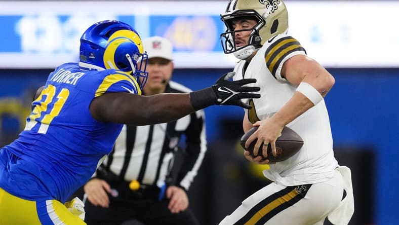 Dec 21, 2023; Inglewood, California, USA; New Orleans Saints quarterback Derek Carr (4) is sacked by Los Angeles Rams defensive tackle Kobie Turner (91) in the first half at SoFi Stadium. Mandatory Credit: Kirby Lee-USA TODAY Sports