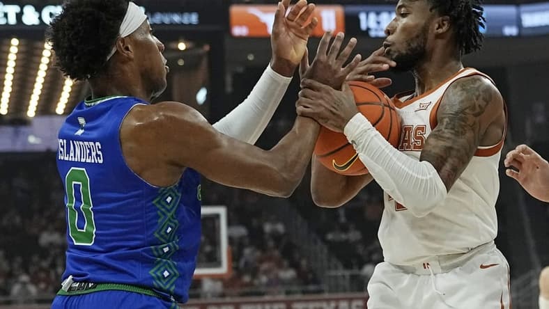Dec 22, 2023; Austin, Texas, USA; Texas Longhorns guard Tyrese Hunter (4) and Texas A&M Corpus Christi guard Chris Johnson (0) battle for the loose ball during the first half at Moody Center. Mandatory Credit: Scott Wachter-USA TODAY Sports