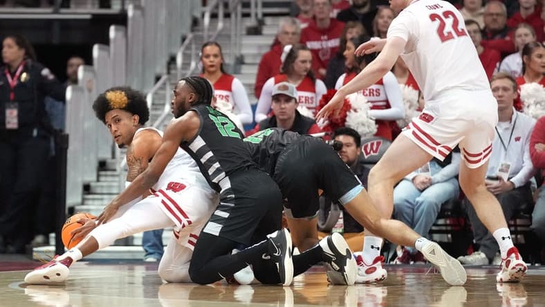 Dec 22, 2023; Madison, Wisconsin, USA; Wisconsin Badgers guard Chucky Hepburn (23) reaches a loose ball before Chicago State Cougars guard Brent Davis (12) as Chicago State Cougars forward Noble Crawford (15) and Wisconsin Badgers forward Steven Crowl (22) look on during the first half at the Kohl Center. Mandatory Credit: Kayla Wolf-USA TODAY Sports