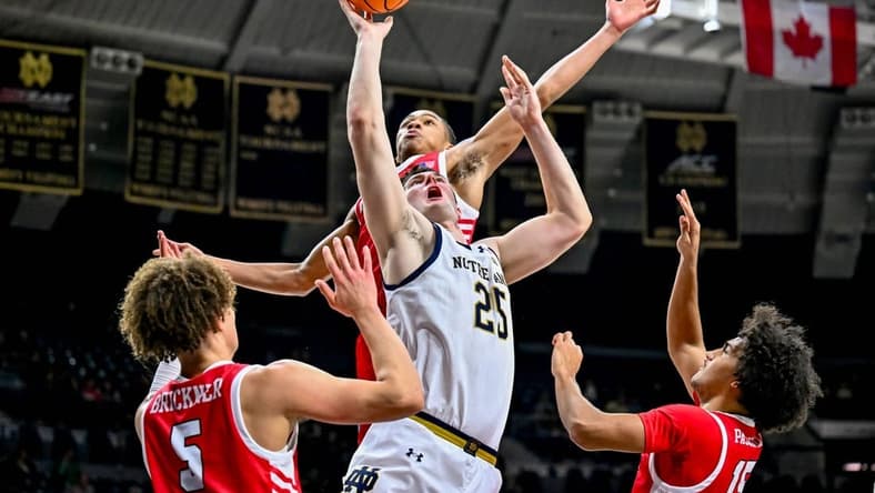 Dec 22, 2023; South Bend, Indiana, USA; Notre Dame Fighting Irish forward Matt Zona (25) goes up for a shot as Marist Red Foxes forward Jaden Daughtry (11) prepares to block in the first half at the Purcell Pavilion. Mandatory Credit: Matt Cashore-USA TODAY Sports
