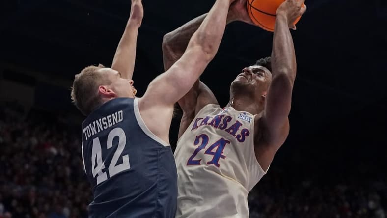 Dec 22, 2023; Lawrence, Kansas, USA; Kansas Jayhawks forward K.J. Adams Jr. (24) shoots and is fouled by Yale Bulldogs forward Nick Townsend (42) during the second half at Allen Fieldhouse. Mandatory Credit: Denny Medley-USA TODAY Sports
