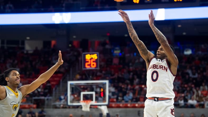Auburn Tigers guard K.D. Johnson (0) shoots a three-pointer as Auburn Tigers take on Alabama State Hornets at Neville Arena in Auburn, Ala., on Friday, Dec. 22, 2023. Auburn Tigers defeated Alabama State Hornets 82-62.