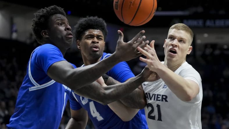 Dec 23, 2023; Cincinnati, Ohio, USA; Seton Hall Pirates guard Kadary Richmond, left, center Elijah Hutchins-Everett, middle, and Xavier Musketeers forward Sasa Ciani, right, battle for a rebound in the first half at the Cintas Center. Mandatory Credit: Aaron Doster-USA TODAY Sports
