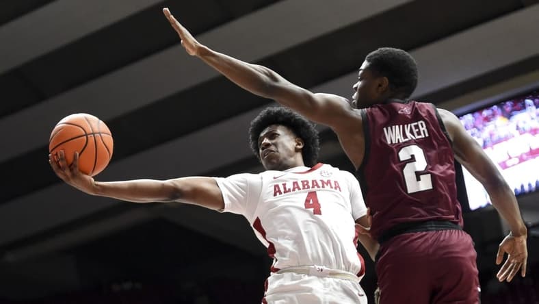 Dec 23, 2023; Tuscaloosa, Alabama, USA; Alabama guard Davin Cosby Jr. (4) attempts a shot inside with Eastern Kentucky guard Leland Walker (2) defending at Coleman Coliseum. Mandatory Credit: Gary Cosby Jr.-USA TODAY Sports