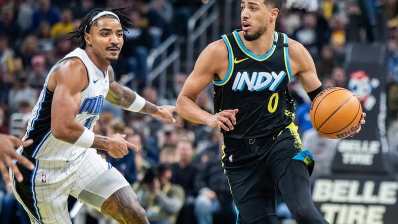 Dec 23, 2023; Indianapolis, Indiana, USA;  Indiana Pacers guard Tyrese Haliburton (0) dribbles the ball while Orlando Magic guard Gary Harris (14) defends in the first quarter at Gainbridge Fieldhouse. Mandatory Credit: Trevor Ruszkowski-USA TODAY Sports