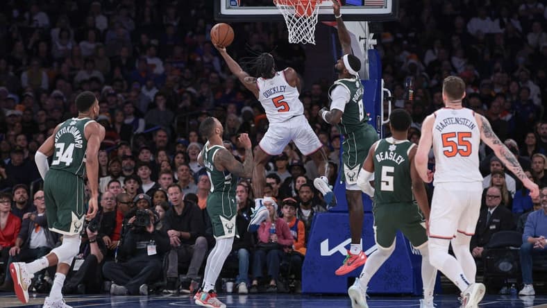 Dec 25, 2023; New York, New York, USA; New York Knicks guard Immanuel Quickley (5) drives to the basket as Milwaukee Bucks forward Bobby Portis (9) and guard Damian Lillard (0) defend during the second half at Madison Square Garden. Mandatory Credit: Vincent Carchietta-USA TODAY Sports