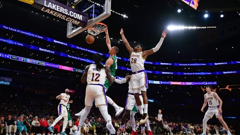 Dec 25, 2023; Los Angeles, California, USA; Boston Celtics center Kristaps Porzingis (8) dunks for the basket against Los Angeles Lakers forward Rui Hachimura (28) and forward Taurean Prince (12) during the second half at Crypto.com Arena. Mandatory Credit: Gary A. Vasquez-USA TODAY Sports